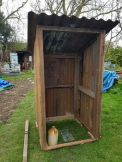 picture showing the shed during restoration with the sides and back repaired and the corrugated roof reinstated