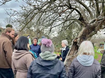 Christina by a tree talking to plot holders